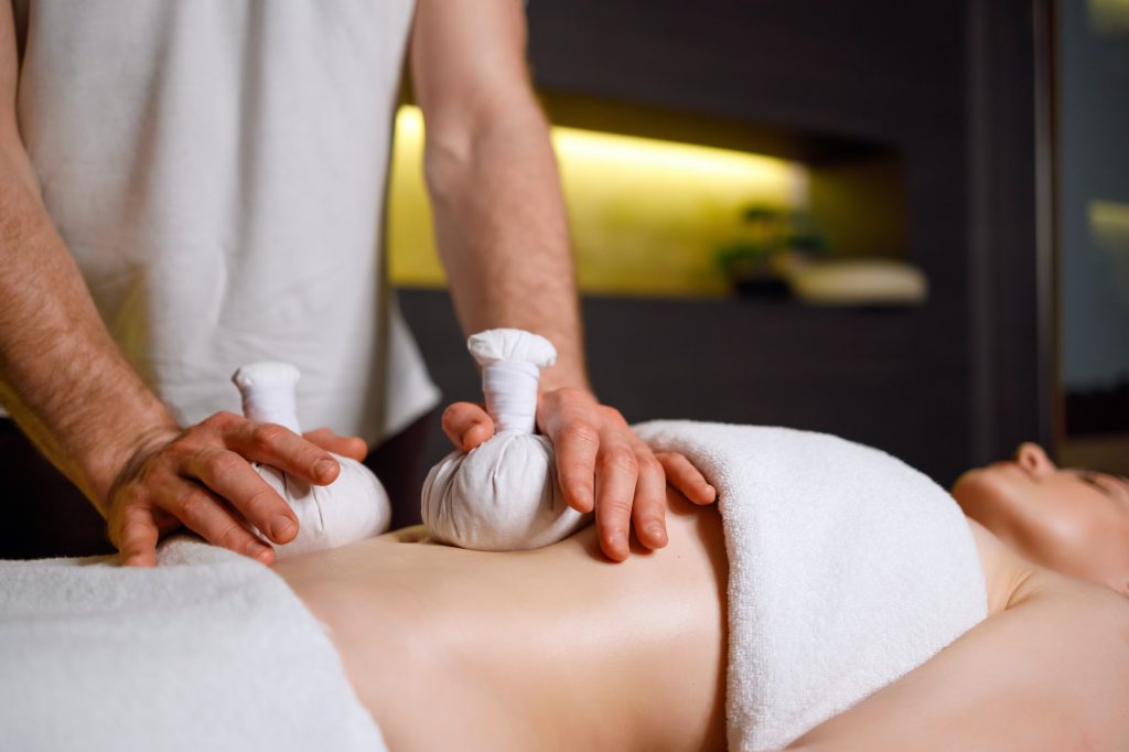 Abdominal massage with warm pindas at spa center