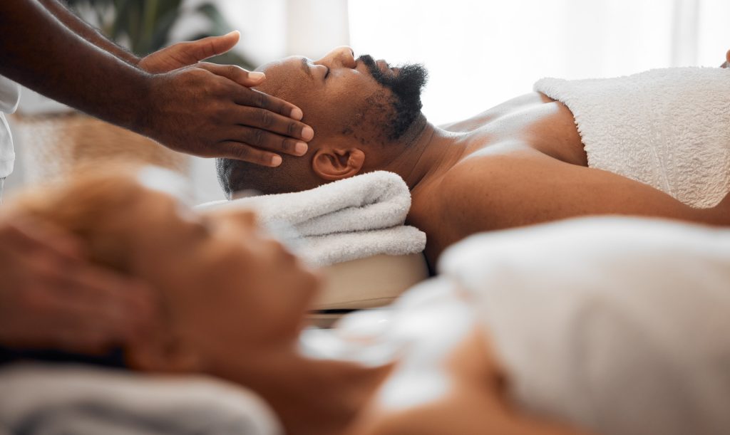 Relax man, head massage and couple on spa massage table for facial, wellness and stress relief ther